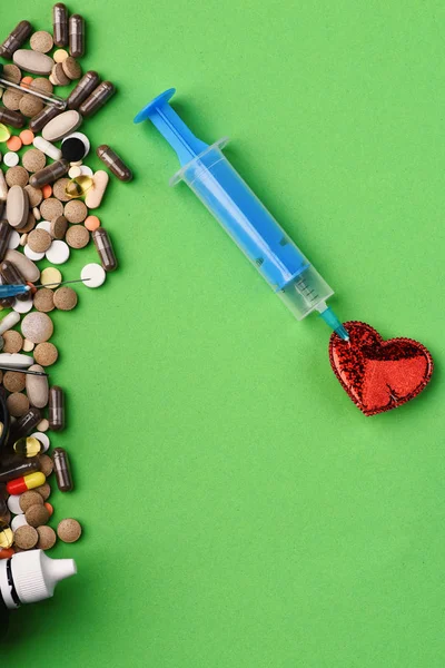 Set of colorful pills scattered on green background