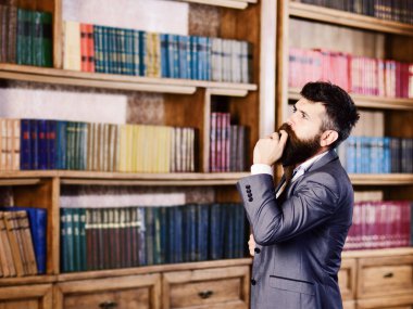 Meraklı adam onun kitaplığında evde kitap seçimi