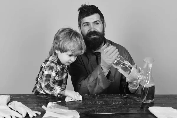 Muž s úsměvem a dítě u stolu na růžovém pozadí. — Stock fotografie