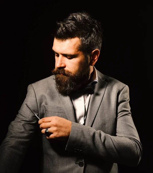 Мужчина с длинной бородой держит лезвие для бритвы рядом с рукой — стоковое фото