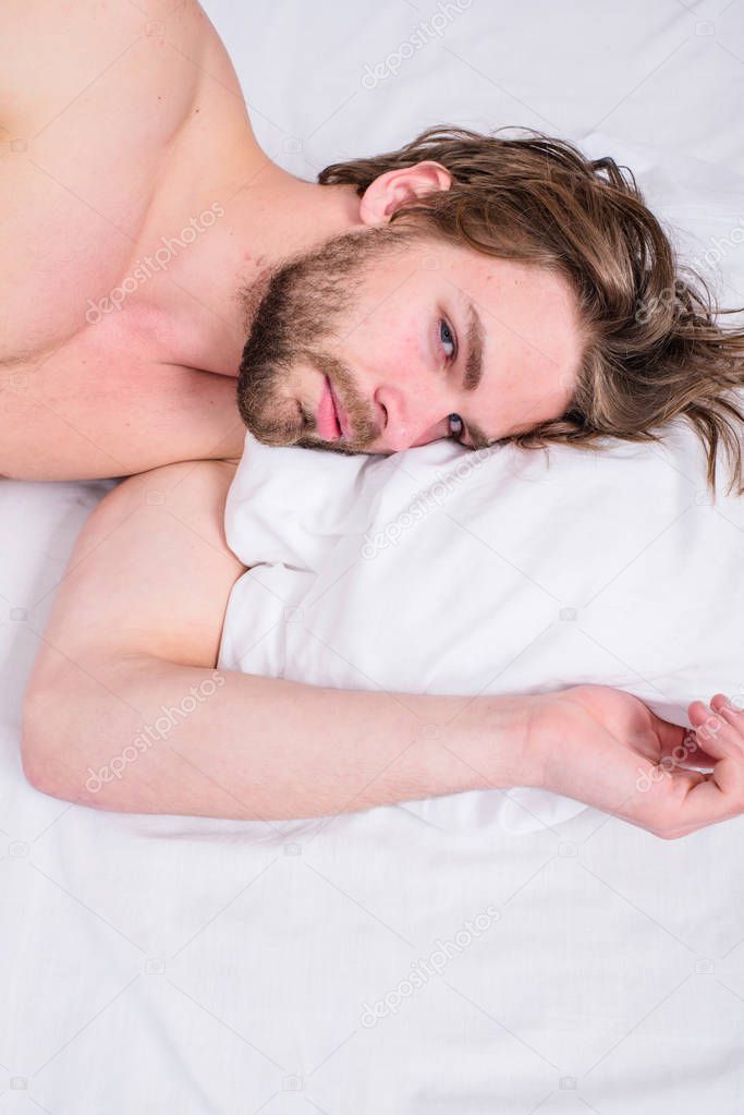 Man unshaven handsome guy naked torso relaxing bed top view. Guy sexy macho lay white bedclothes. Man sleepy drowsy bearded face having rest. Guy sleepy morning nap. Pleasant awakening concept