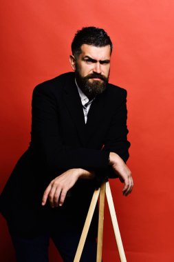 Maço erkek fotoğraf makinesi tripod üzerinde kırmızı bir arka plan üzerinde eğilir