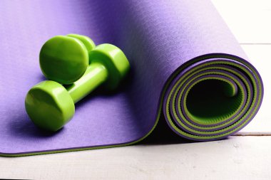 Spor ve spor konsepti. Yeşil plastikten yapılmış dambıllar