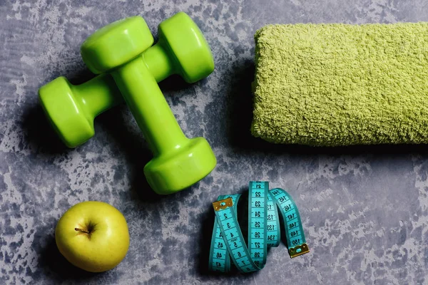 Trening i pojęcie zdrowego stylu życia... Hantle w zielonym kolorze, apple — Zdjęcie stockowe