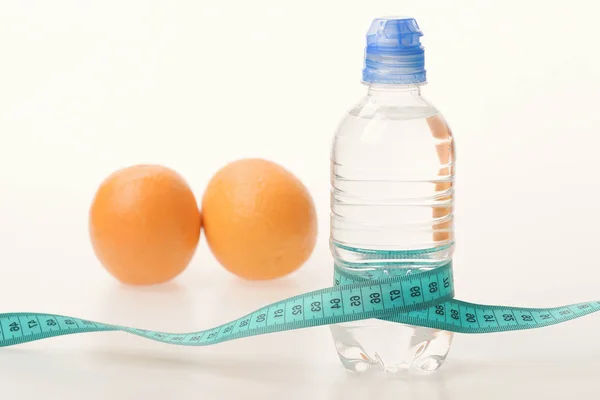 Botella de agua envuelta con cinta métrica y fruta — Foto de Stock