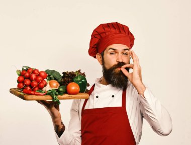 Burgonya üniformalı bir aşçı salata malzemesi taşır.