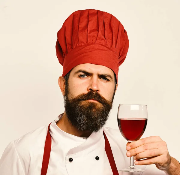 Kocken håller i ett glas rött vin. Man med skägg — Stockfoto