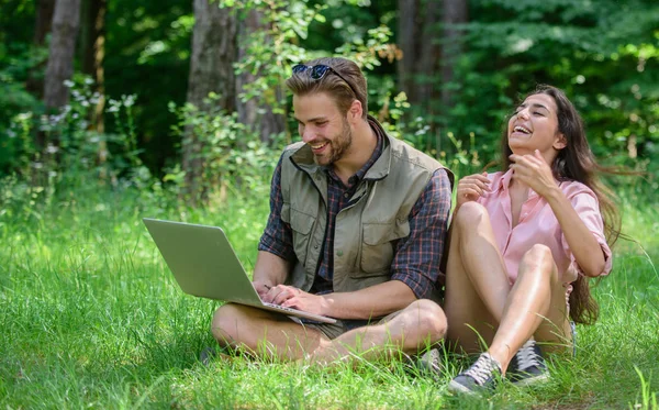 Couple youth spend leisure outdoors with laptop. Man and girl looking at laptop screen. Modern technologies give opportunity to be online and work in any environment conditions. Nature best workspace