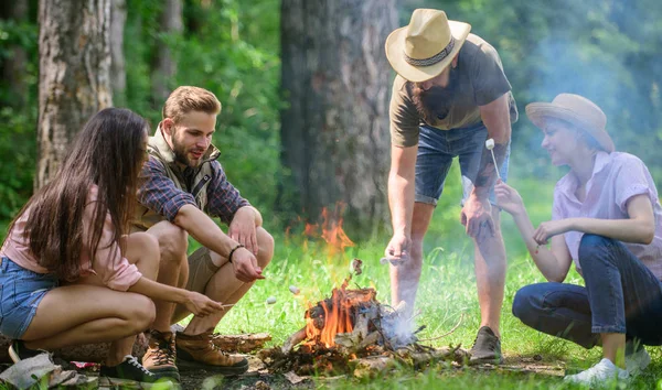 Prażenie marshmallows popularnej grupy działalności wokół ogniska. Przyjaciele firmy przygotować porcję palone tle natura przekąska. Camping aktywności. Firma młodzieży camping Las prażenie marshmallows — Zdjęcie stockowe