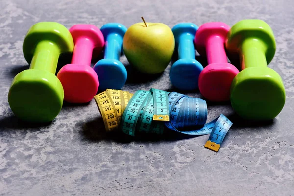 Barbells, tape measures and apple placed in pattern, close up — Stock Photo, Image
