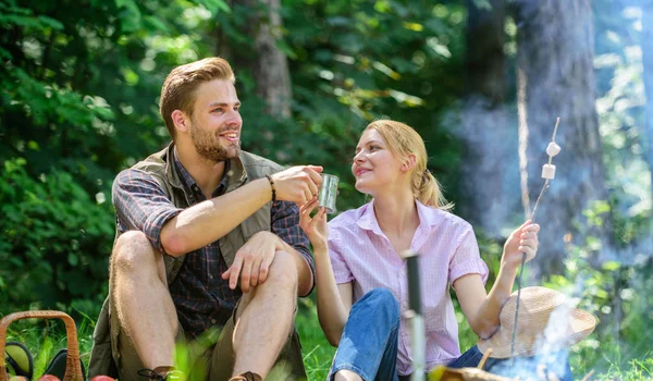 Food for hike and camping. Couple sit near bonfire eat snacks and drink. Weekend picnic. Couple take break to eat nature background. Couple in love camping forest hike. Hike snacks and beverages