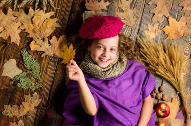 Çocuk yatıyordu ahşap arka plan yaprakları yukarıdan düşmüş. Aksesuar moda ayrıntı ördü. Çocuk kız moda giyim örme şapka bere ve atkı. Sonbahar moda aksesuarları kavramı. Moda trend sonbahar sezon