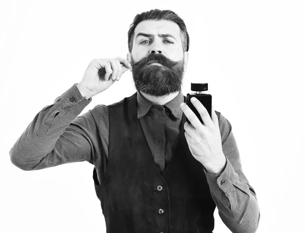 Szakállas férfi kezében parfüm komoly arccal — Stock Fotó