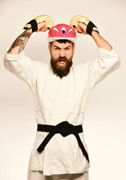 Martial arts. Man with beard in kimono and pink helmet