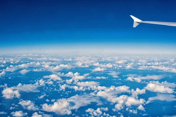 Sunny blue cloudy sky and plane wing — Stock Photo, Image