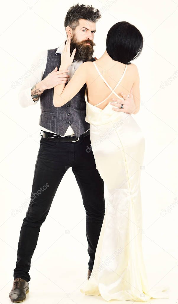 Modern wedding concept. Hipster with lady dressed up for wedding ceremony. Couple in love, bride and groom in elegant clothes, white background. Woman in wedding dress with nude back and man in vest