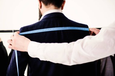 Terzilerin elleri dikiş takımı için ölçü alır, beyaz arkaplan.