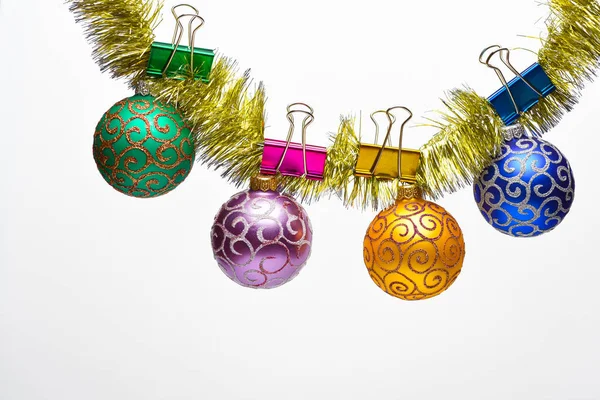 Christmas ornaments concept. Tinsel with pinned christmas balls or ornaments, white background, copy space. Balls with glitter ornaments hang on shimmering golden tinsel — Stock Photo, Image