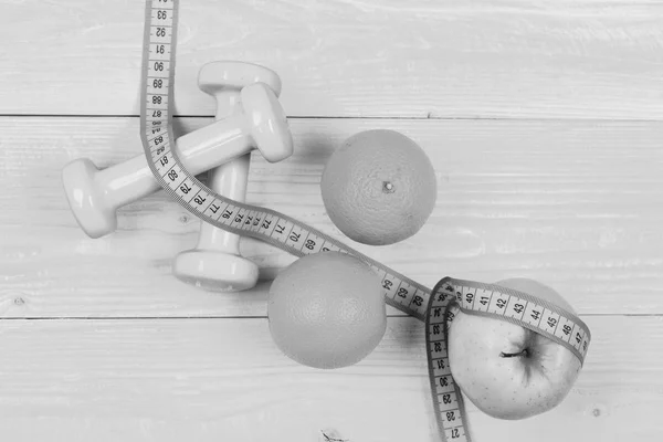 Diet concept, dumbbells weight with measuring tape, orange and apple — Stock Photo, Image