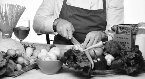Cook burgundy egyenruha darabolja zöldségek. A séf elkészíti az ételt.. — Stock Fotó