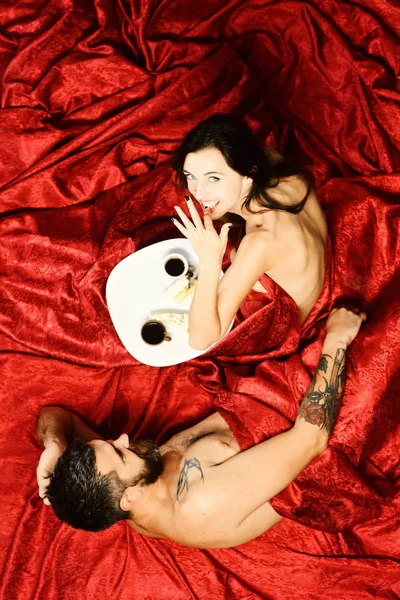 Hombre y mujer con cuerpos medio cubiertos comen pastel — Foto de Stock