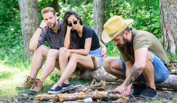 How build bonfire outdoors. Camping weekend leisure. Arrange woods twigs or sticks. Man brutal bearded hipster prepares bonfire in forest. Ultimate guide to bonfires. Company friends camping forest — Stock Photo, Image