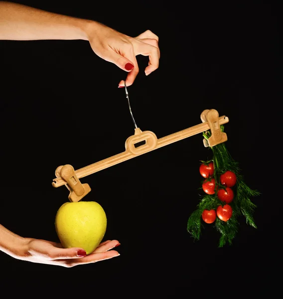 Kvinnlig hand håller hängare med frukt och grönsaker på spetsarna — Stockfoto