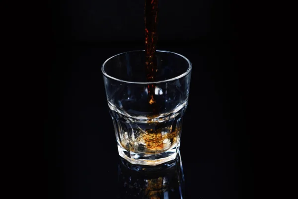 Splash-ital, üveg whiskey-t, a fekete háttér, másol hely. — Stock Fotó