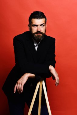 Maço erkek fotoğraf makinesi tripod üzerinde kırmızı bir arka plan üzerinde eğilir