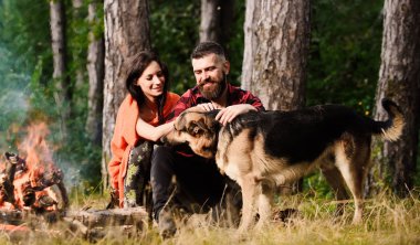 Şenlik ateşinin yanında çoban köpeği olan Pat Alman çoban köpeği..