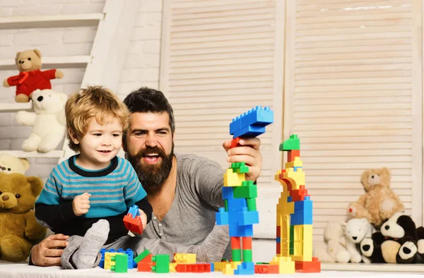 Padre e hijo con caras felices crean construcciones coloridas —  Fotos de Stock