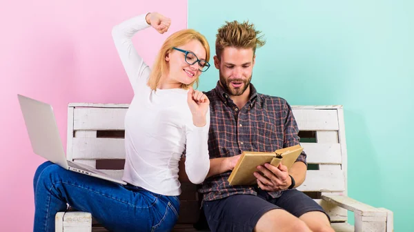 Moderna eleverna använda digital inställning samt klassiska läroböcker. Man och kvinna använder olika lärande tillvägagångssätt. Studenter som är trött på att studera. Par elever med bok och laptop studerar — Stockfoto