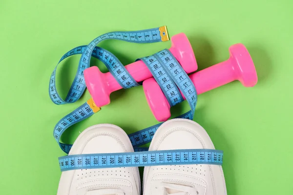 Zentimeter in blauer Farbe auf Turnschuhen und pinkfarbenen Hanteln — Stockfoto