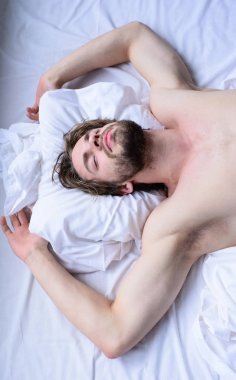 Adam seksi maço beyaz yatak örtüsü yatıyordu. Adam uykulu tıraşsız sakallı yüzü uyku dinlenme vardır. Hoş rüya kavramı. Bırak vücudun rahat hissediyorum. Adam tıraşsız yakışıklı adam çıplak gövde uyku nap yatakta