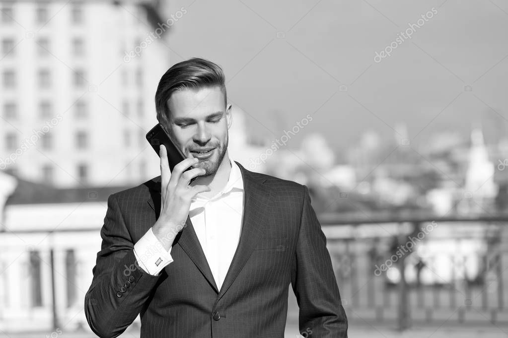 Happy man with mobile phone on sunny terrace. Businessman use smartphone with smile. Great business news. Business communication. Communication and agile business. New technology and modern life