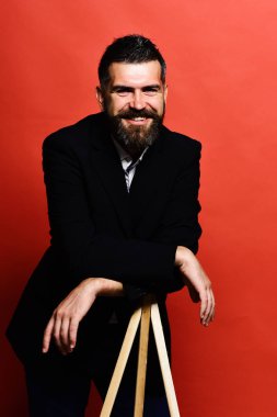 Maço erkek fotoğraf makinesi tripod üzerinde kırmızı bir arka plan üzerinde eğilir