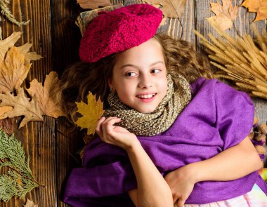 Sonbahar moda örgü aksesuar. Örme şapka trend sonbahar sezonu. Kız yatıyordu ahşap arka plan yaprakları yukarıdan düşmüş. Aksesuar moda ayrıntı ördü. Çocuk kız parlak yumuşak örme şapka bere