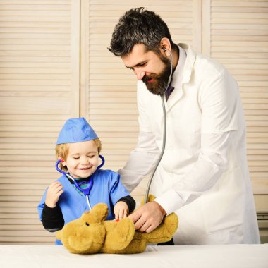 Mutlu yüzlü baba ve çocuk doktorculuk oynuyor.