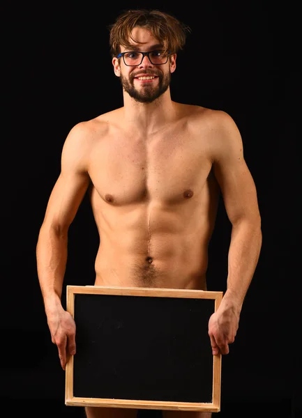 Hombre sexy torso muscular mantenga pizarra delante de su cuerpo desnudo. Macho atractivo desnudo chico mantenga pizarra. Hombre inteligente y sexy con barba y pelo rizado lleva gafas. Anuncio para adultos —  Fotos de Stock