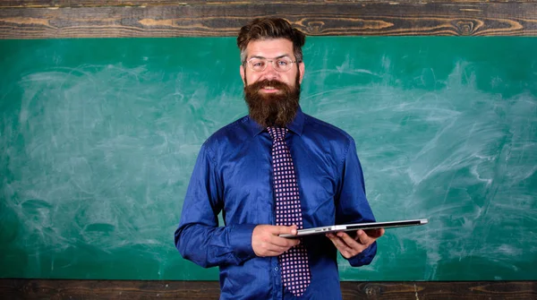 Commence la leçon. Professeur barbu homme avec fond moderne tableau noir ordinateur portable. Éducation aux technologies modernes. Professeur hipster porter des lunettes et cravate tient ordinateur portable. Éducation aux technologies numériques — Photo