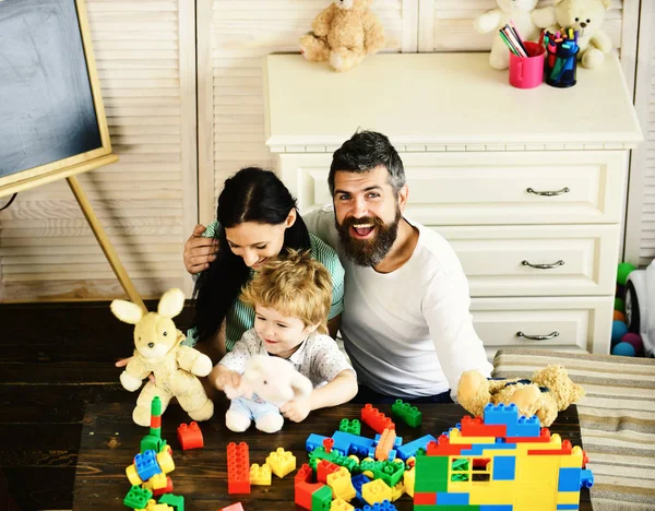 Mamma, pappa och pojke leker med vita mjuka leksaker — Stockfoto