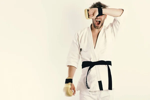 Guy poses in white kimono wearing golden boxing gloves — Stock Photo, Image