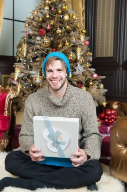 Hediye kutusu oturup Noel ağaç adam gülümseyerek