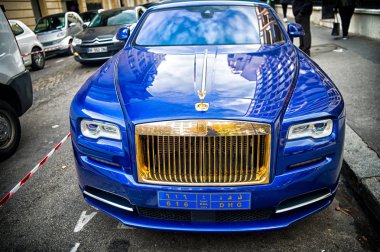 Lüks Supercar Royce Rolls Royce 'u Paris' te caddeye park etmiş mavi ve altın rengi bir hayalet olarak gösteriyor. Rolls Royce Rolls-Royce ünlü pahalı otomobil markasıdır.