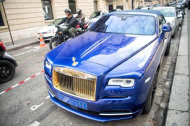 Lüks Supercar Royce Rolls Royce 'u Paris' te caddeye park etmiş mavi ve altın rengi bir hayalet olarak gösteriyor. Rolls Royce Rolls-Royce ünlü pahalı otomobil markasıdır.