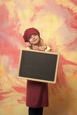 küçük mutlu kız Şef şapkalı, önlük ile yazı tahtası