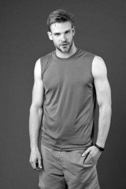 Menekşe arka plan üzerinde atlet. Turuncu yeleği ve mavi şort, spor giyim moda kaslı adam. Zinde ve kendinden emin. Spor moda eğitim ve egzersiz için. Fitness ve sağlıklı yaşam