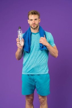 Stay hydrated. Man with towel on shoulders hold bottle. Athlete drink hydration mix with more electrolytes. Hydrates faster than water alone with an optimal ratio of carbohydrates. Keep you hydrated clipart