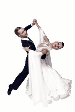 Dans eden balo çifti beyaz sahilde yalnız poz veriyor.