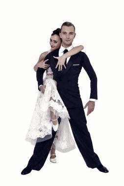 Dans eden balo çifti beyaz sahilde yalnız poz veriyor.